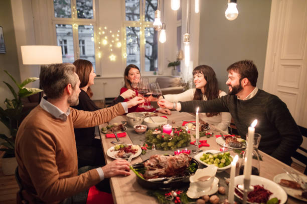 istock friends toasting wine glasses at dining table during Christmas 871395854