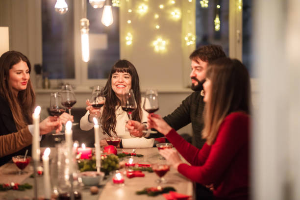 istock friends toasting wine glasses at dining table during Christmas 871396358