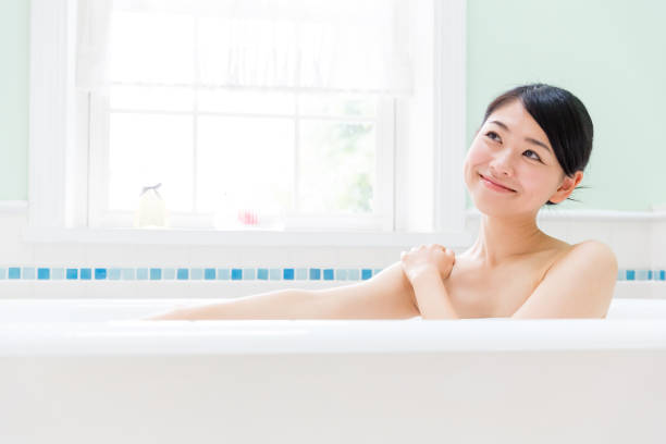 jeune femme asiatique dans salle de bain - prendre un bain photos et images de collection