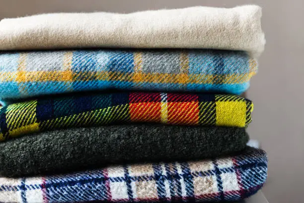 Stack of woolen checked blankets, autumn and winter concept