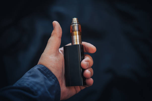 istock Vaping device in in the man's hand. Electronic cigarette, vape 871413816
