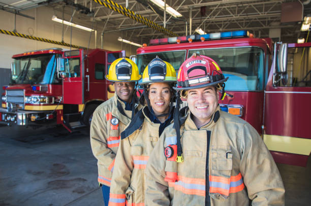 Firefighter A stock group/team of firefighters looking into the camera. emergency services occupation stock pictures, royalty-free photos & images