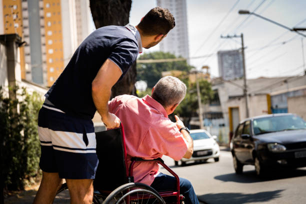 istock Son helping his dad sitting in his wheelchair 871427634