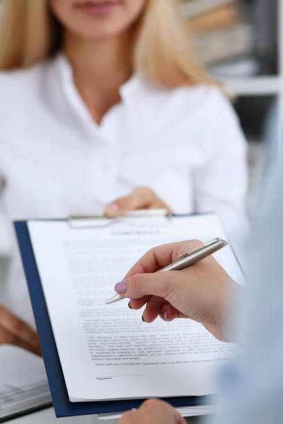 istock Female arm in white shirt offer contract form 871427954
