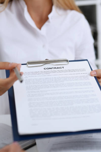 istock Female arm in white shirt offer contract form 871427986