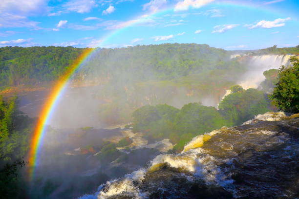 über beeindruckende iguacu fällt landschaft mit regenbogen auf der seite von argentinien, dramatischer schönheit in natur landschaft - idyllische teufelskehle - internationale grenze des brasilianischen foz iguacu, parana, puerto iguazu, misiones und pa - iguacu falls argentina tropical rainforest rainbow stock-fotos und bilder