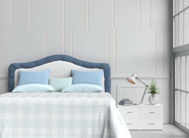 istock White bed room decorated with tree in glass vase, blue&green pillows, white wood bedside table,table light green blanket, Window, Lamp, Book, White wall it is pattern, white cement floor.3d rendering. 871431048