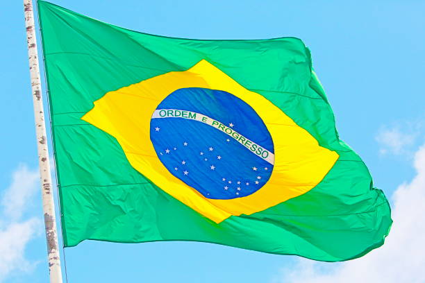 istock Ordem e Progresso – Order and Progress: Colorful Brazillian Flag with pole mast waving in the Sky – Rio de janeiro, Brazil 871431514