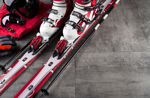 Winter sport theme. Ski equipment on gray tiles. Place for typography.