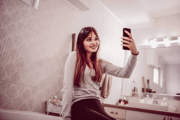 istock Cute Female Taking Selfie in Her Bathroom 871444866
