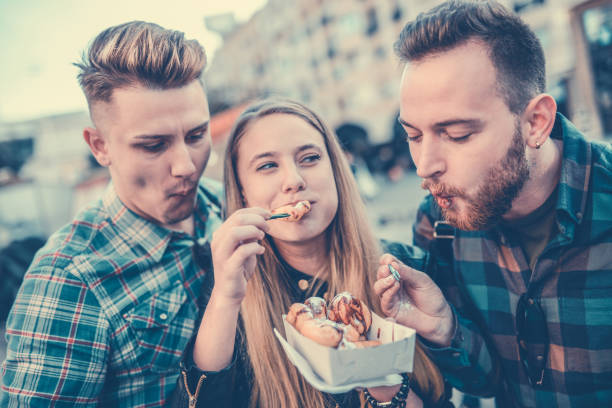 istock Smiling Friends Sharing Donuts and Having a Great Time 871448144