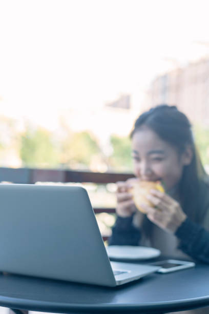 istock woman having lunch in cafe with laptop on table 871450820