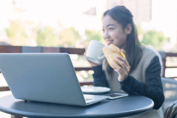 istock woman having lunch in cafe with laptop on table 871450840