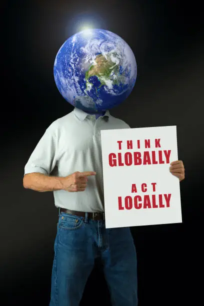 Photo of Think Globally Act Locally environmental message man with Earth head