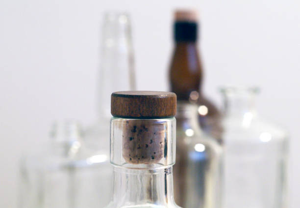istock Vintage clear glass liquor bottles with cork in focus with plain background 871468276