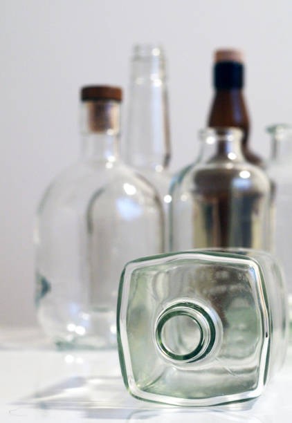 istock Vintage clear glass liquor bottles with one on its side with plain background 871468286