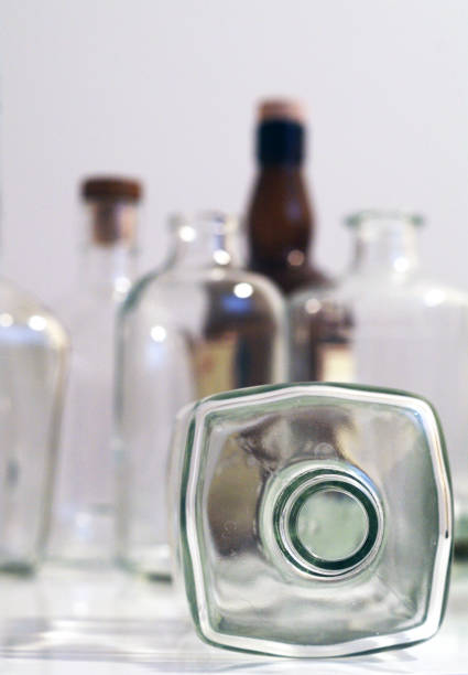istock Vintage clear glass liquor bottles with one on its side with plain background 871468288