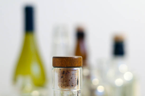 Vintage clear glass liquor bottles with cork in focus with plain background