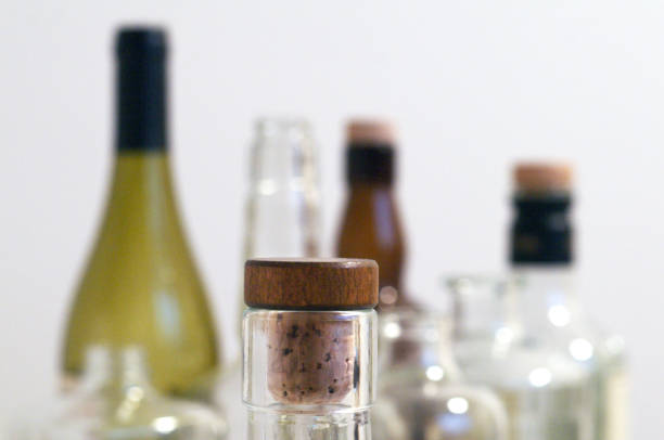 Vintage clear glass liquor bottles with cork in focus with plain background