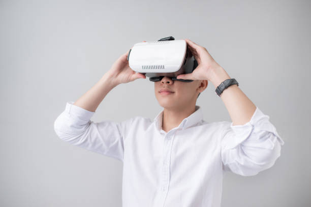 istock Excited asian man in a VR goggles and gesturing with his hands 871471064