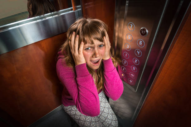 shocked woman with claustrophobia in the moving elevator - claustrophobic imagens e fotografias de stock