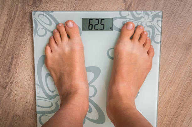istock Female feet on personal scales 871475622