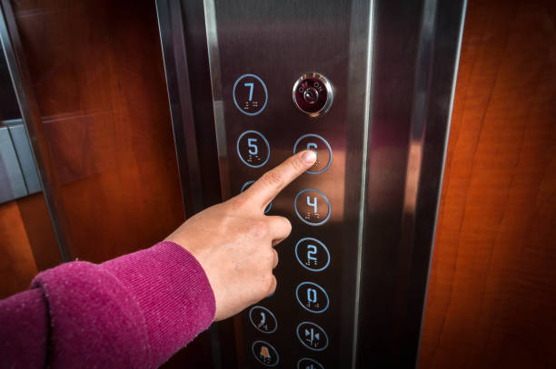 istock Woman pressing the button in the elevator interior 871475818