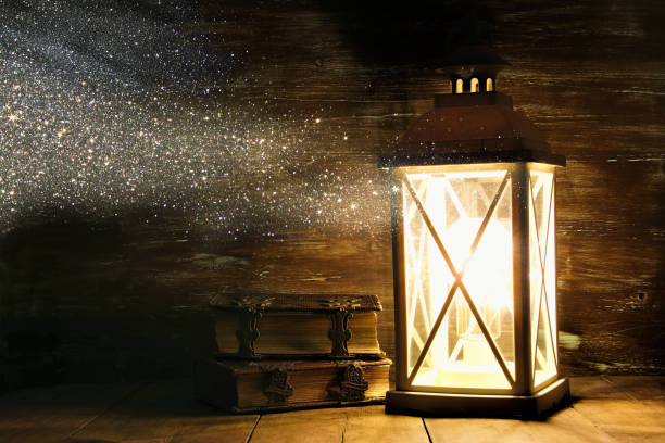 istock Vintage Lantern next to old books on wooden table 871478424