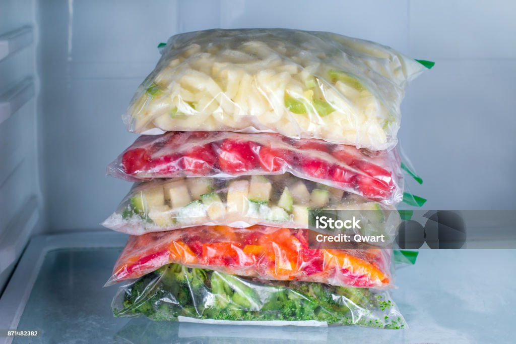 Sacs avec des légumes congelés dans le réfrigérateur, closeup - Photo de Glacé libre de droits