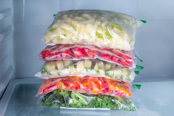 Bags with frozen vegetables in refrigerator, closeup
