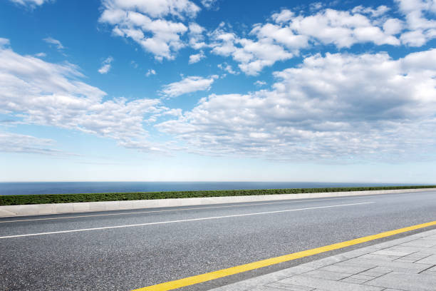 istock empty asphalt road with blue sea in blue sky 871483266