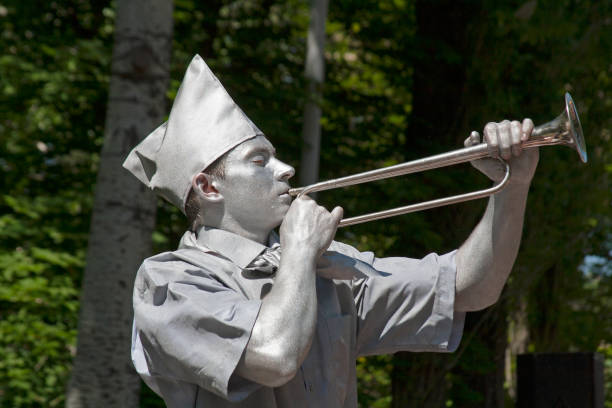 silver painted artist with horn trumpet dressed as soviet pioneer on a city street - bugle trumpet brass old fashioned imagens e fotografias de stock