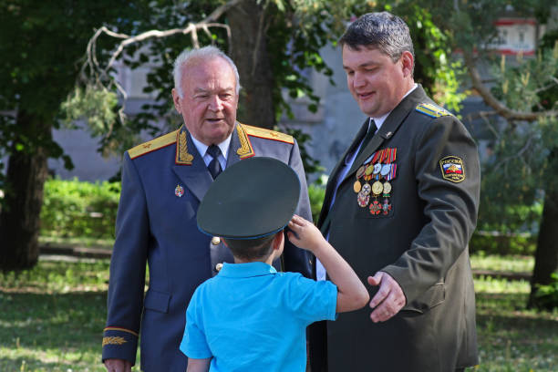 the boy in the cap saluting seniors in rank on victory day in volgograd - solider major army saluting imagens e fotografias de stock