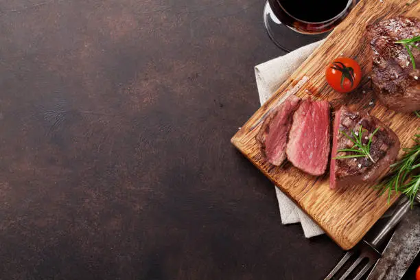 Grilled fillet steak with red wine on stone table. Top view with space for your text