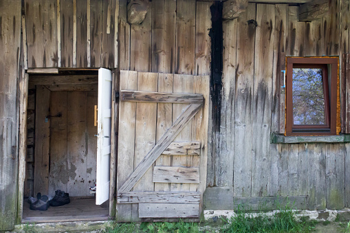 Facade with open door old wooden rural house