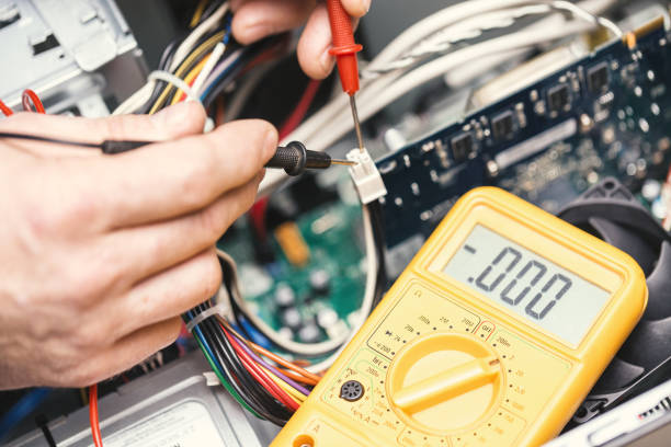 istock Technician hands with voltmeter above computer motherboard. Repair of computers concept. Toned with selective focus 871490676