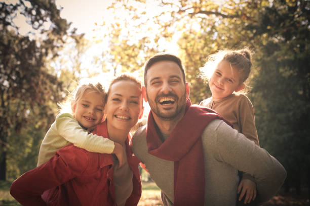 istock Parents carrying daughters on piggyback. 871490990