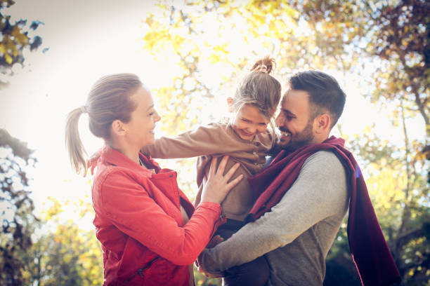 istock Mom and daddy walking with daughter, care her on arms. 871494818