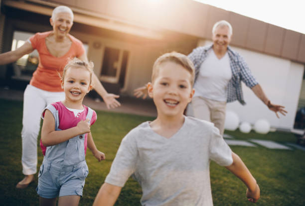 istock Happy grandparents having fun while chasing their joyful grandkids in the back yard. 871498048