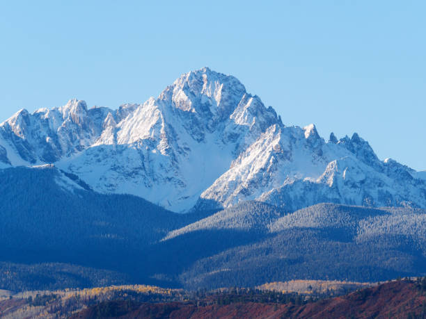 Close up of snow covered Sneffels Range in a bright daylight blue sky in fall foliage autumn season near Ridgway, Colorado, USA. Close up of snow covered Sneffels Range in a bright daylight blue sky in fall foliage autumn season near Ridgway, Colorado, USA. sneffels range stock pictures, royalty-free photos & images