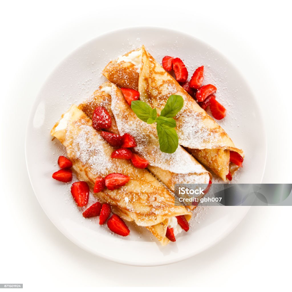 Crepes with strawberries and cream Crepes with strawberries and cream on white background Plate Stock Photo