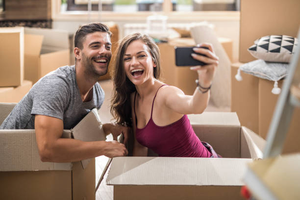 istock Happy couple having fun while taking a selfie at their new home. 871505492