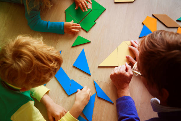 istock teacher and kids playing with geometric shapes 871509614