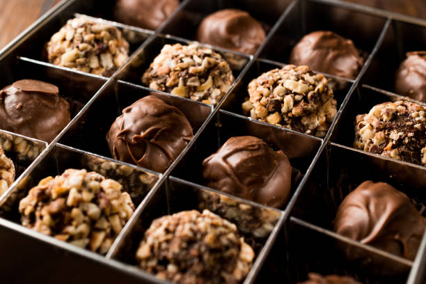 Box of Chocolate Pralines with Hazelnuts. Box of Chocolate Pralines with Hazelnuts. Dessert Concept. chocolate pieces stock pictures, royalty-free photos & images