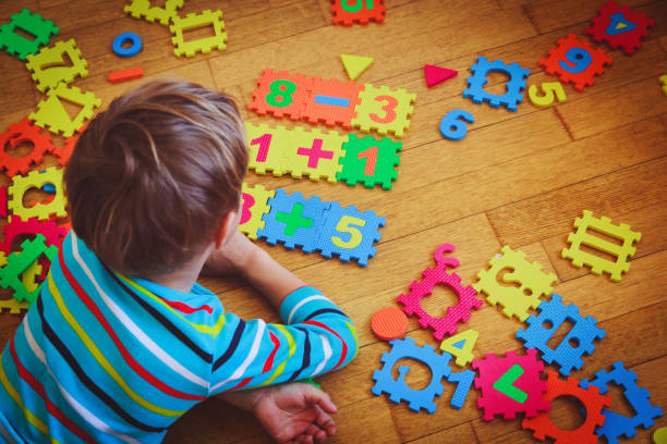 istock little boy playing with puzzle, education concept 871510590