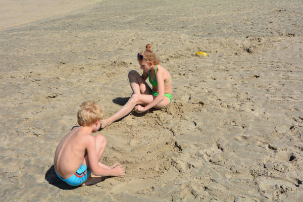 istock Two children play on the sandy beach 871516470