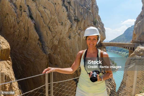 Mature Beautiful Tourist Woman Hiking While Holding Camera Against View Of The Mountains Stock Photo - Download Image Now