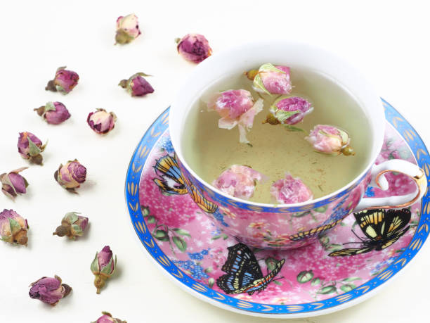 istock Cup of rose bud tea on a white wooden board 871518104