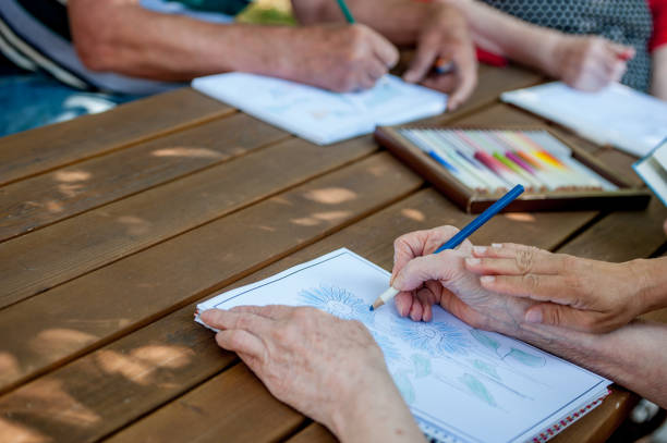 istock Close Up Senior Hands Drawing And Coloring 871518358