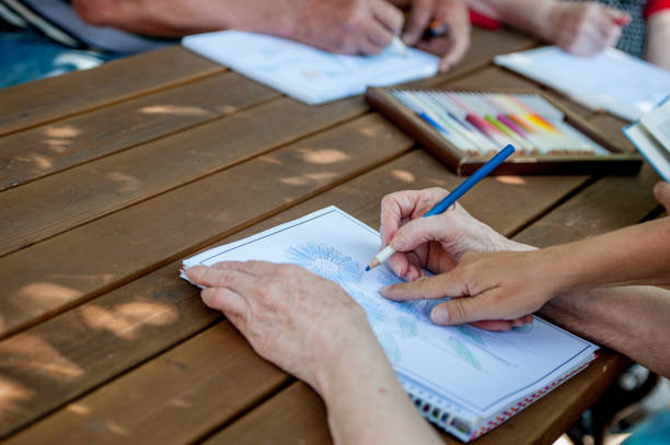 istock Close Up Senior Hands Drawing And Coloring 871518382